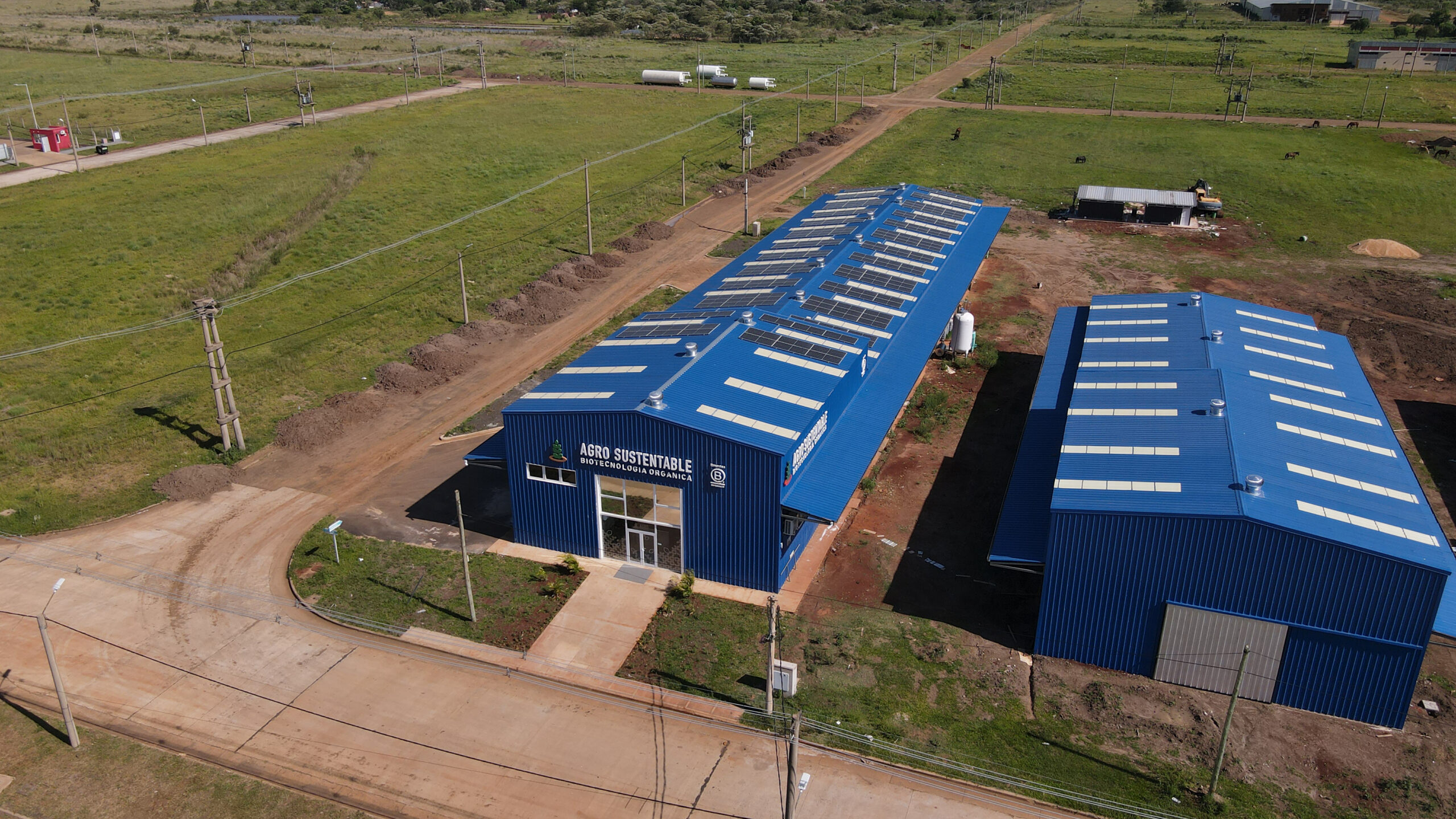 Instalación industrial de AG TEch de Agro Sustentable vista desde el aire, con paneles solares en los techos y entorno rural.